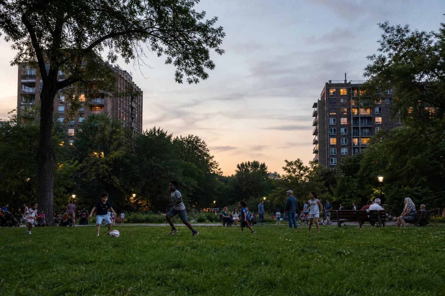 Children and neighbors share a city park at dusk.